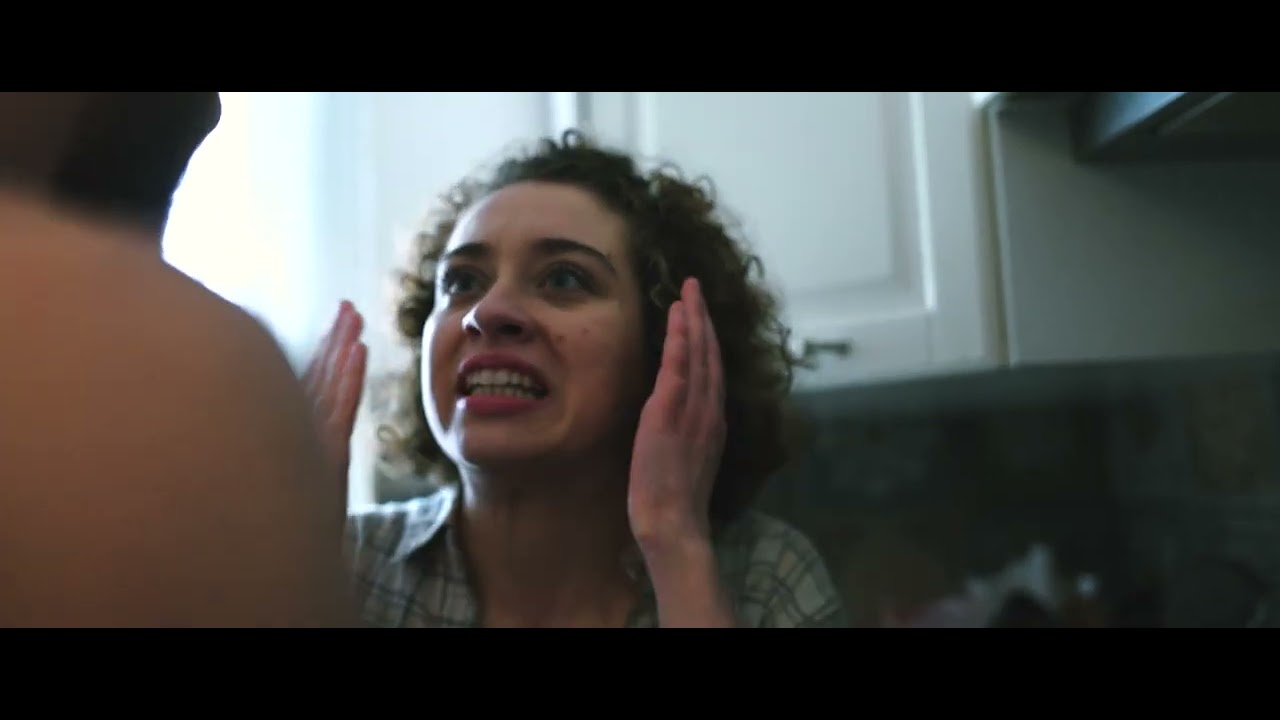 Frame from non oggi: a woman in a kitchen, hands near her face. It is the video thumbnail, not a portrait of Vittorio Russo.