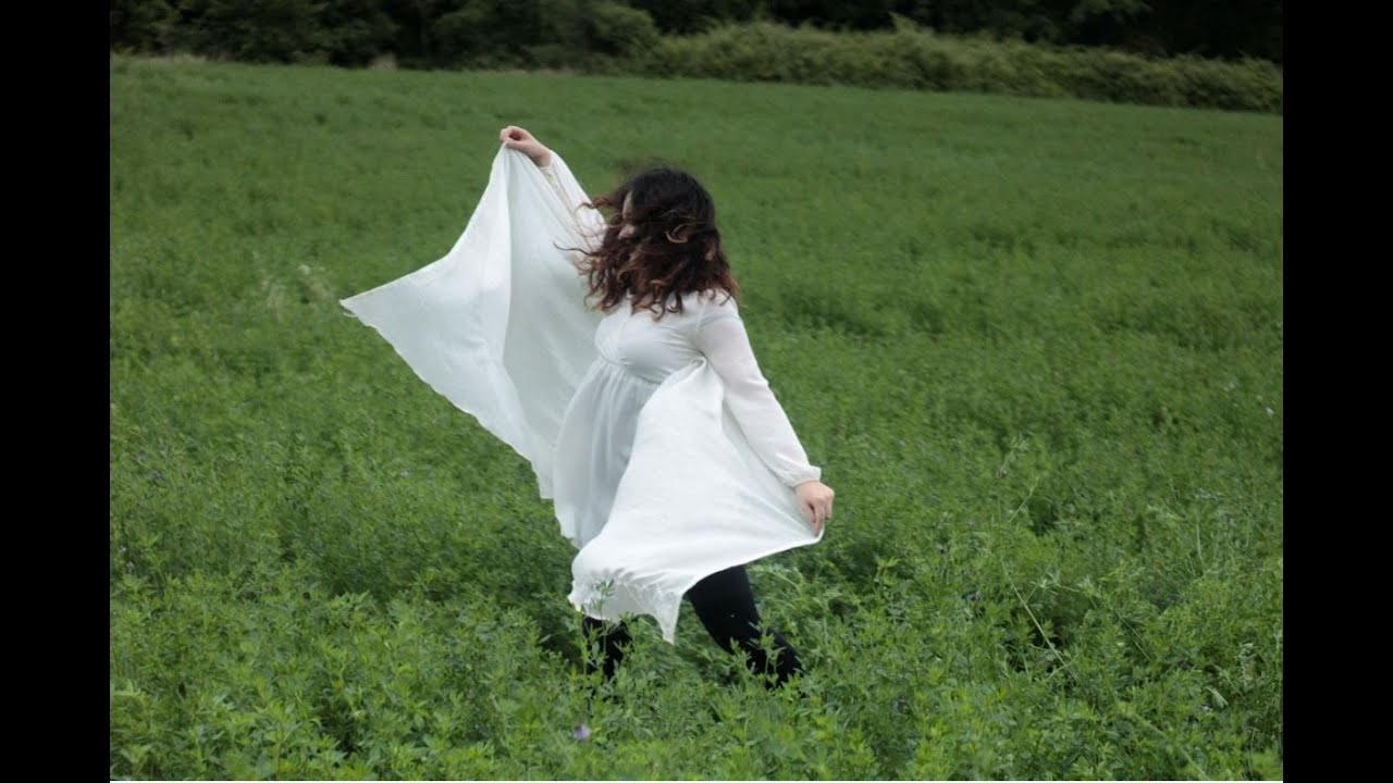 Frame from Obfuscated: a figure in white in a field.
