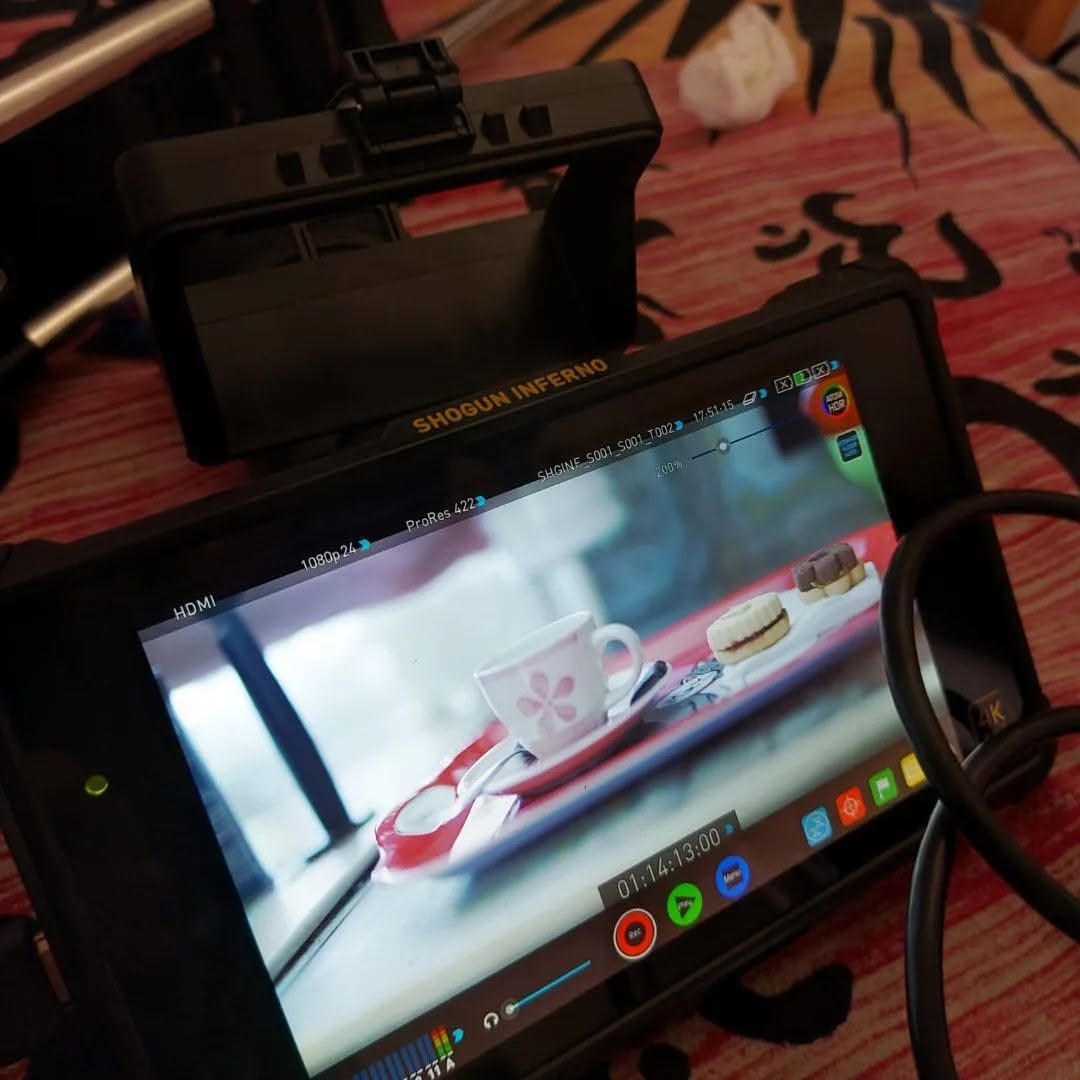 A "SHOGUN INFERNO" monitor shows a cup and pastries on a tray, with cables and recording controls.